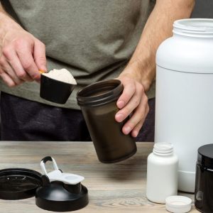 the-athlete-pours-protein-into-a-shaker-the-concept-of-sports-nutrition-1024x684